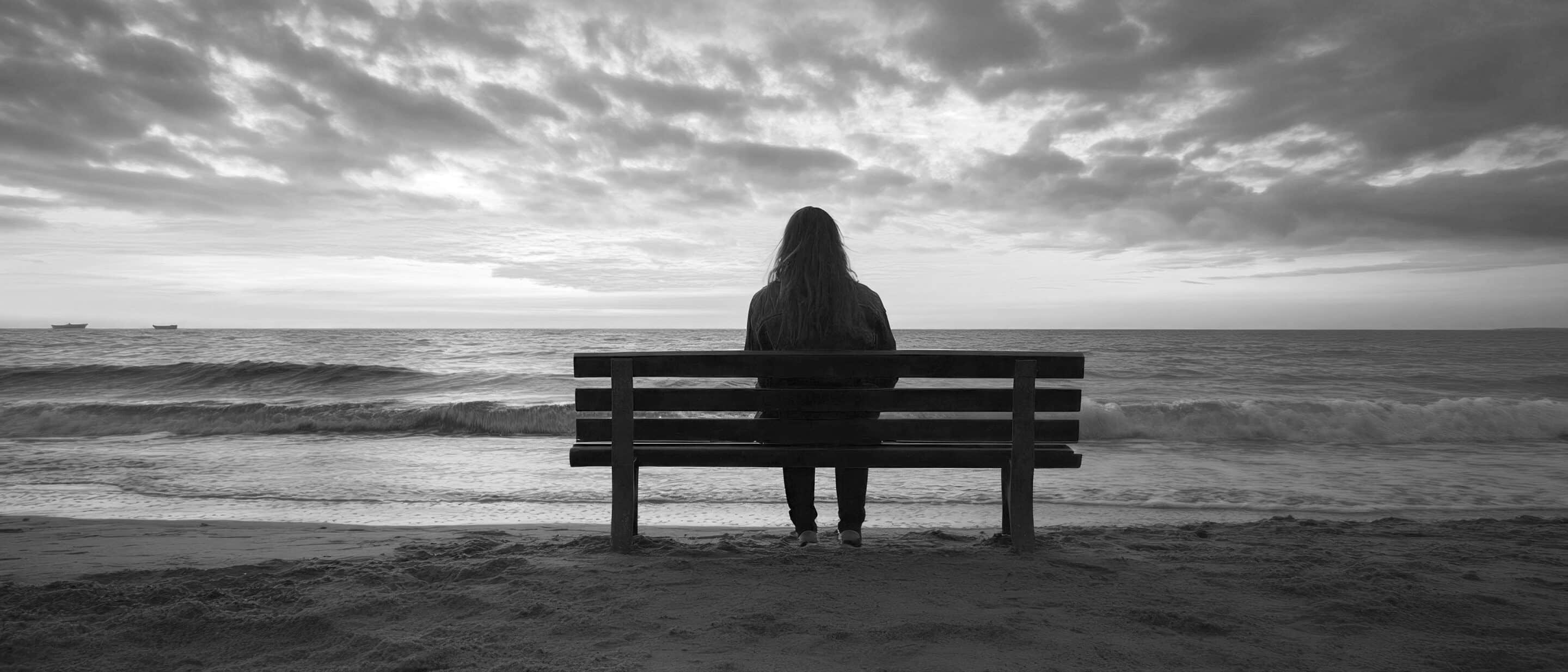 At sunset by the sea, a solitary figure contemplates eternity, emphasising the melancholy of nature — the perfect atmospheric backdrop for philosophical articles or meditative apps.